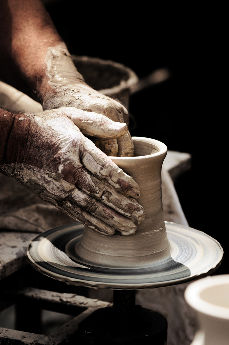 Potters Hands turning a beaker on potter wheel.